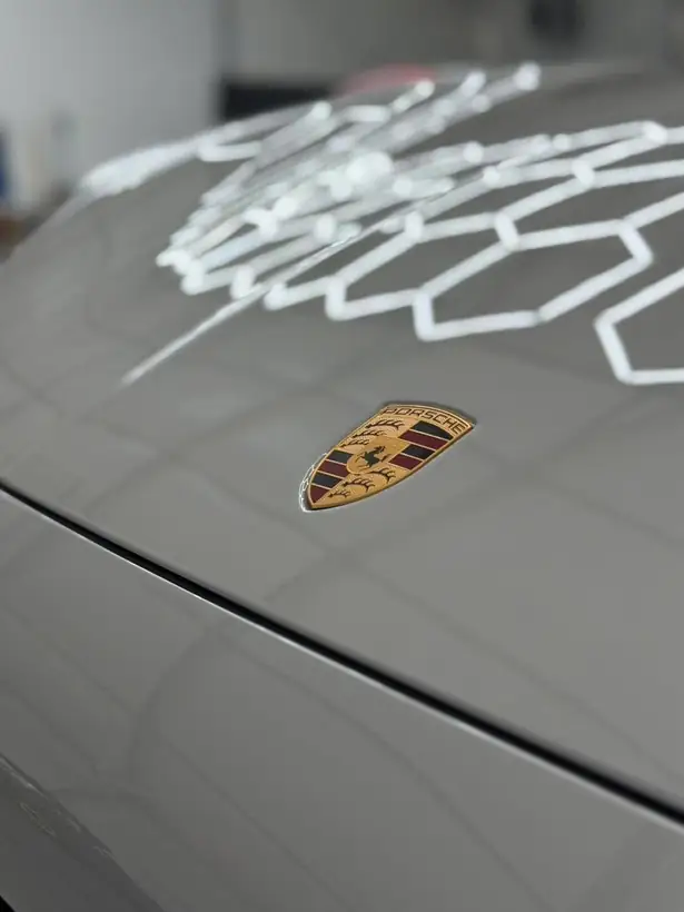 Logo Porsche na wypolerowanej masce